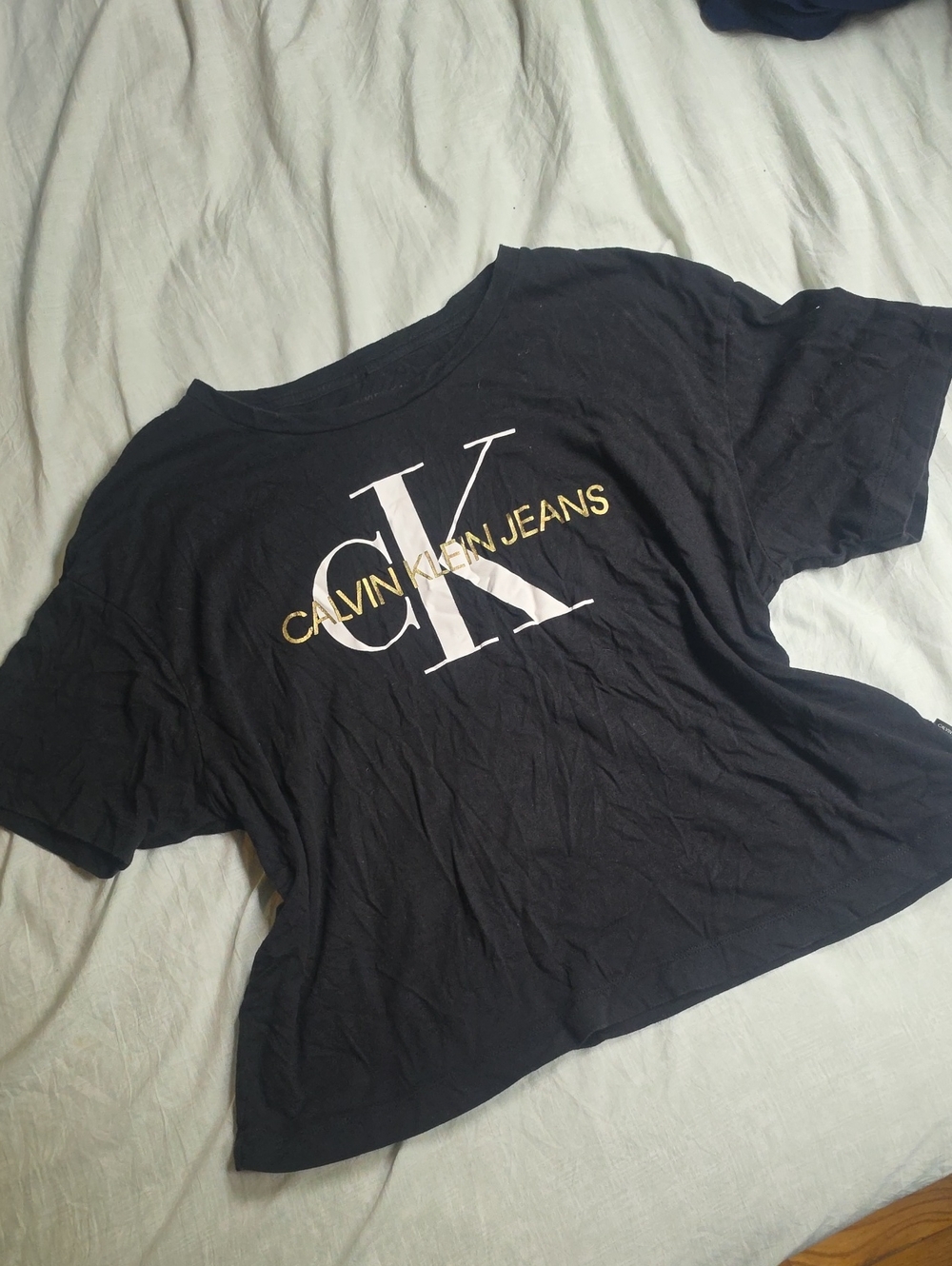 Calvin Klein Jeans Black Tee with White CK and Gold Lettering